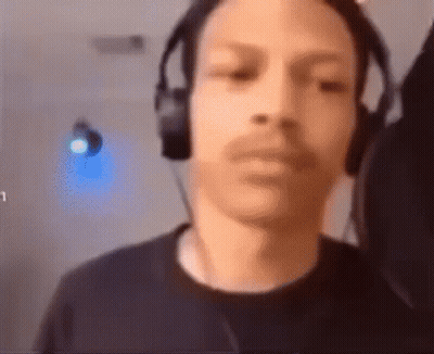 A Man Wearing Headphones Is Looking At The Camera And Making A Funny Face . GIF