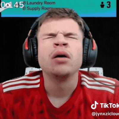 A Man Wearing Headphones Is Making A Face In Front Of A Laundry Room Sign GIF