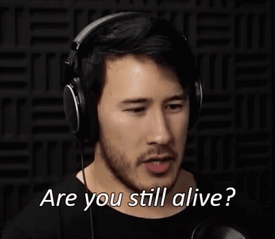 A Man Wearing Headphones Is Making A Funny Face And Asking Are You Still Alive . GIF
