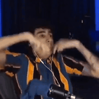 A Man Wearing Headphones Is Making A Funny Face In Front Of A Microphone . GIF