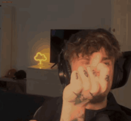 A Man Wearing Headphones Is Making A Funny Face While Holding A Lightning Bolt In His Hand . GIF