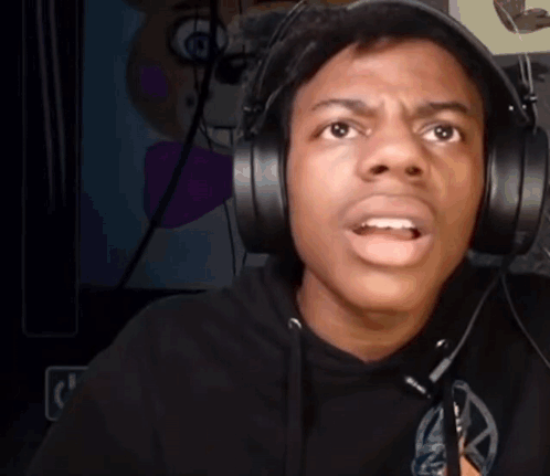 A Man Wearing Headphones Is Making A Funny Face While Looking At The Camera . GIF