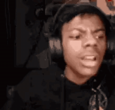 A Man Wearing Headphones Is Making A Funny Face While Sitting In A Chair . GIF