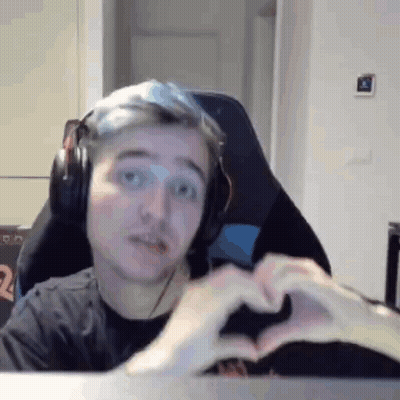 A Man Wearing Headphones Is Making A Heart With His Hands While Sitting In A Chair . GIF