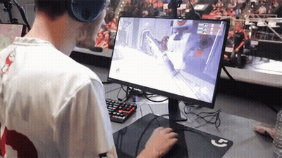 A Man Wearing Headphones Is Playing A Video Game On A Dell Computer GIF