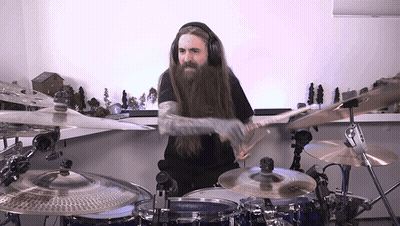A Man Wearing Headphones Is Playing Drums GIF