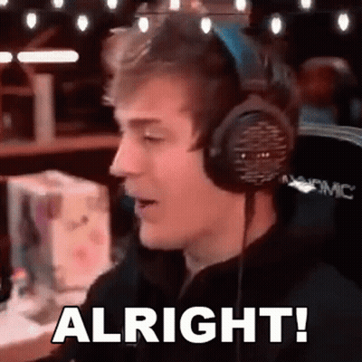 A Man Wearing Headphones Is Saying `` Alright '' While Sitting In Front Of A Computer . GIF