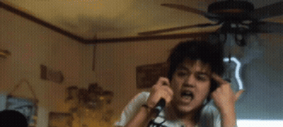 A Man Wearing Headphones Is Singing Into A Microphone In Front Of A Sign That Says Route 66 GIF