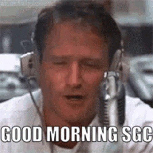 A Man Wearing Headphones Is Singing Into A Microphone . GIF