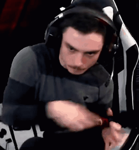 A Man Wearing Headphones Is Sitting In A Chair And Looking At Something GIF