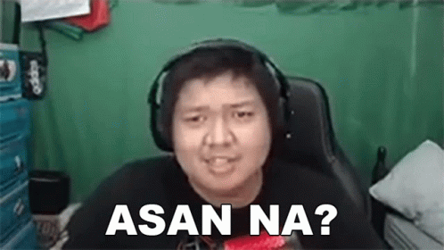 A Man Wearing Headphones Is Sitting In A Chair And Making A Face . GIF