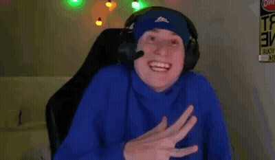 A Man Wearing Headphones Is Sitting In A Chair And Smiling . GIF