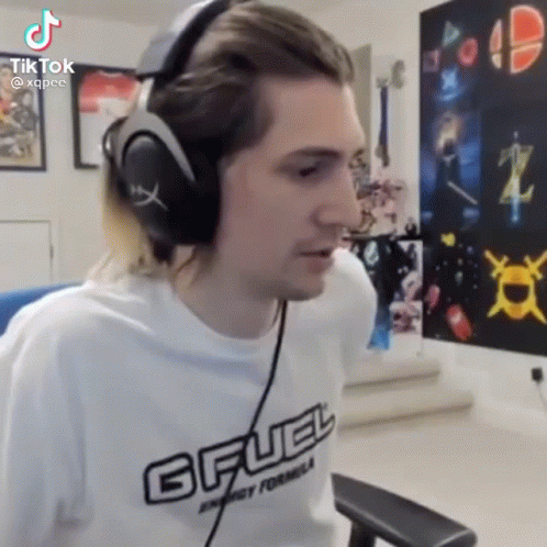 A Man Wearing Headphones Is Sitting In A Chair In A Living Room . GIF