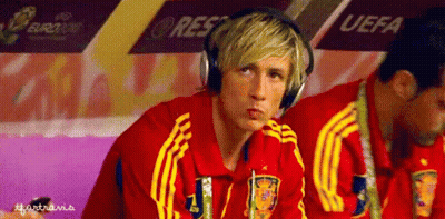 A Man Wearing Headphones Is Sitting In A Locker Room With Uefa Written On The Wall Behind Him GIF