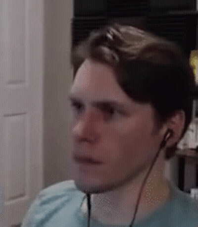 A Man Wearing Headphones Is Sitting In Front Of A Computer Monitor . GIF