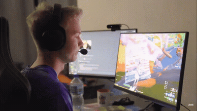 A Man Wearing Headphones Is Sitting In Front Of A Computer Monitor GIF