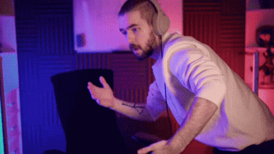 A Man Wearing Headphones Is Sitting In Front Of A Computer Screen GIF