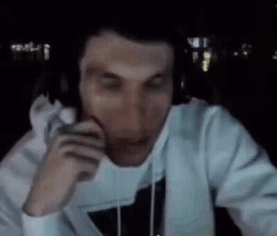 A Man Wearing Headphones Is Sitting In Front Of A Computer Screen In A Dark Room . GIF