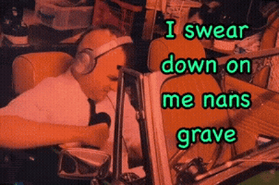 A Man Wearing Headphones Is Sitting In Front Of A Computer With The Words I Swear Down On Me Nans Grave Below Him GIF
