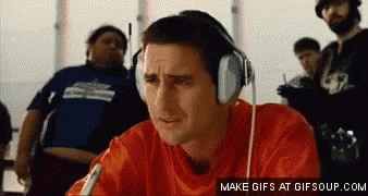 A Man Wearing Headphones Is Sitting In Front Of A Group Of People GIF