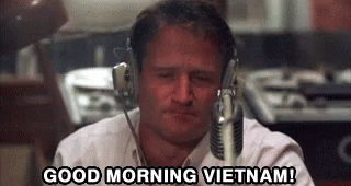 A Man Wearing Headphones Is Sitting In Front Of A Microphone . GIF