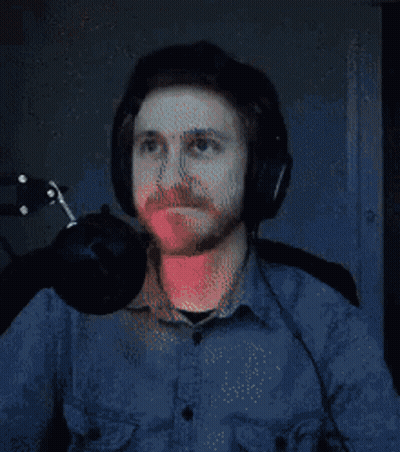 A Man Wearing Headphones Is Sitting In Front Of A Microphone And Looking Up . GIF