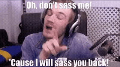 A Man Wearing Headphones Is Sitting In Front Of A Microphone And Making A Face . GIF