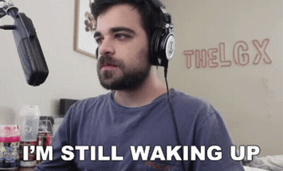 A Man Wearing Headphones Is Sitting In Front Of A Microphone And Says I 'M Still Waking Up GIF