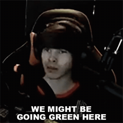 A Man Wearing Headphones Is Sitting In Front Of A Microphone And Says We Might Be Going Green Here . GIF