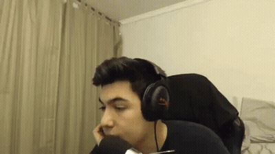 A Man Wearing Headphones Is Sitting In Front Of A Microphone In A Room . GIF