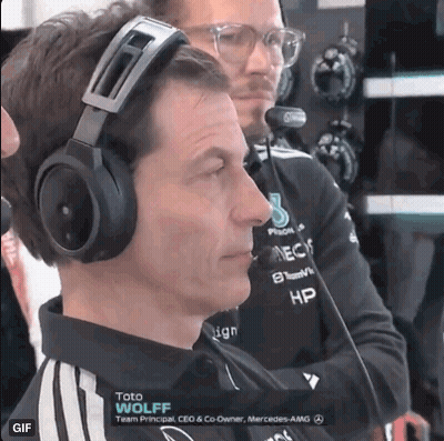 A Man Wearing Headphones Is Sitting In Front Of A Microphone While Another Man Looks On . GIF