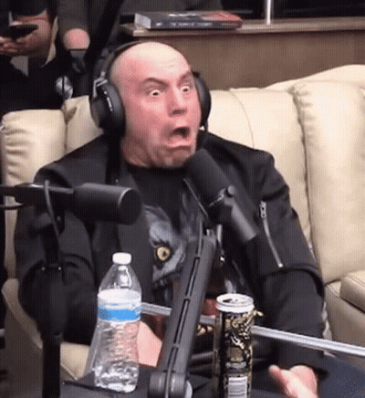 A Man Wearing Headphones Is Sitting In Front Of A Microphone With A Can Of Soda And A Bottle Of Water . GIF