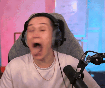 A Man Wearing Headphones Is Sitting In Front Of A Microphone With His Mouth Open GIF