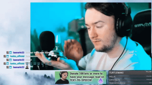 A Man Wearing Headphones Is Sitting In Front Of A Screen That Says Turtlewake On It GIF