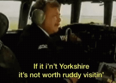 A Man Wearing Headphones Is Sitting In The Cockpit Of A Plane And Talking . GIF