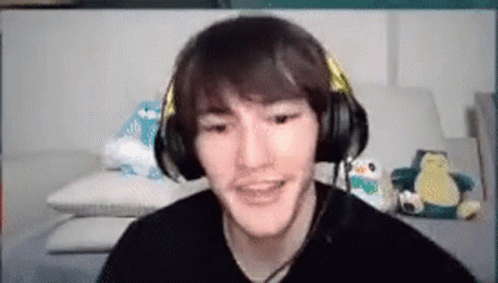 A Man Wearing Headphones Is Sitting On A Couch . GIF