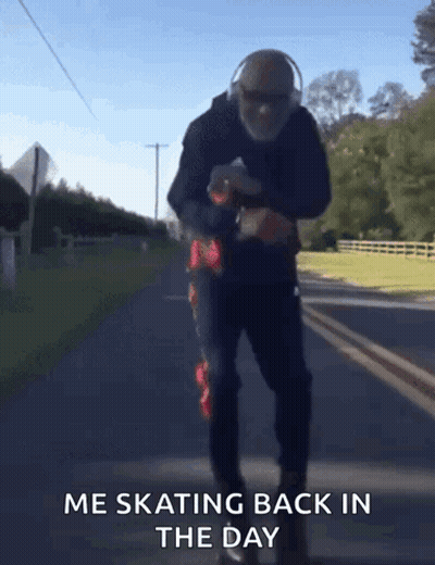 A Man Wearing Headphones Is Skating Down A Road With The Words Me Skating Back In The Day Below Him GIF