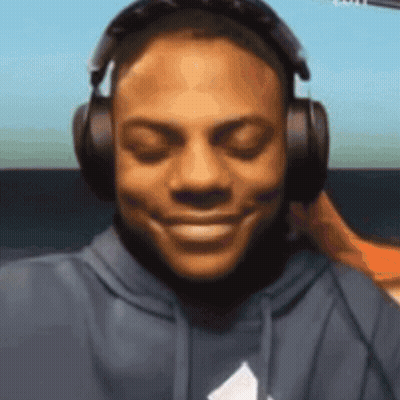 A Man Wearing Headphones Is Smiling And Looking At The Camera GIF