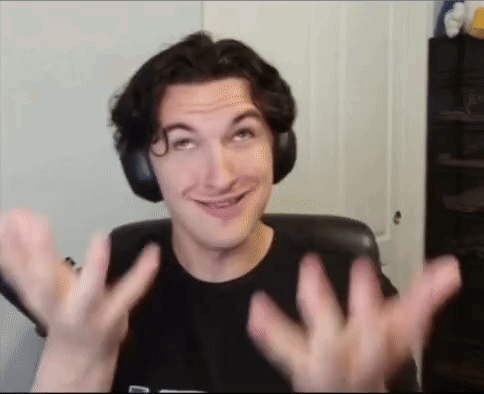 A Man Wearing Headphones Is Smiling And Making A Funny Face While Sitting In A Chair . GIF