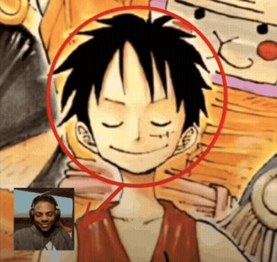 A Man Wearing Headphones Is Smiling In Front Of A Drawing Of Monkey D Luffy GIF