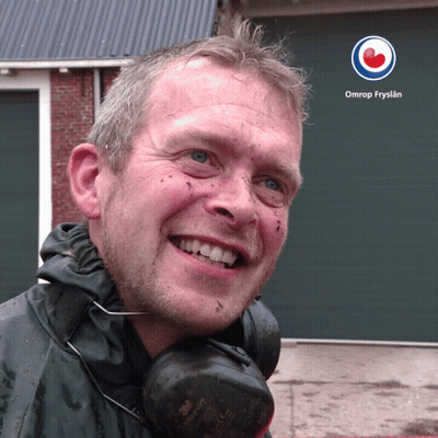 A Man Wearing Headphones Is Smiling In Front Of A Omrop Fryslan Logo GIF
