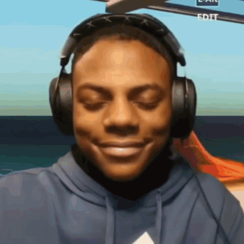 A Man Wearing Headphones Is Smiling In Front Of A Screen That Says Edit On It GIF
