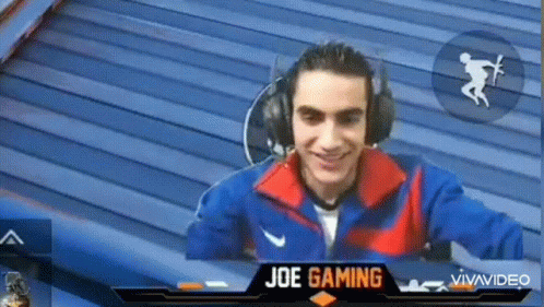 A Man Wearing Headphones Is Smiling In Front Of A Screen That Says Joe Gaming On It GIF