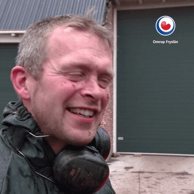 A Man Wearing Headphones Is Smiling In Front Of An Omrop Fryslan Logo GIF