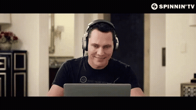 A Man Wearing Headphones Is Smiling While Looking At A Laptop Screen Sponsored By Spinnin 'Tv GIF