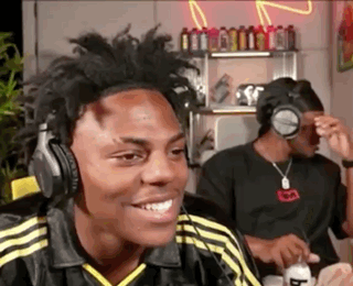 A Man Wearing Headphones Is Smiling While Sitting In A Room . GIF