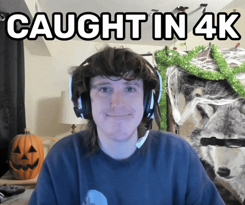 A Man Wearing Headphones Is Smiling With The Words Caught In 4K Above Him GIF