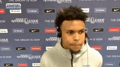 A Man Wearing Headphones Is Standing In Front Of A Wall That Says League Finals GIF
