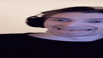 A Man Wearing Headphones Is Sticking His Tongue Out While Making A Funny Face . GIF