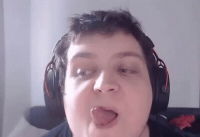A Man Wearing Headphones Is Sticking His Tongue Out While Making A Funny Face . GIF